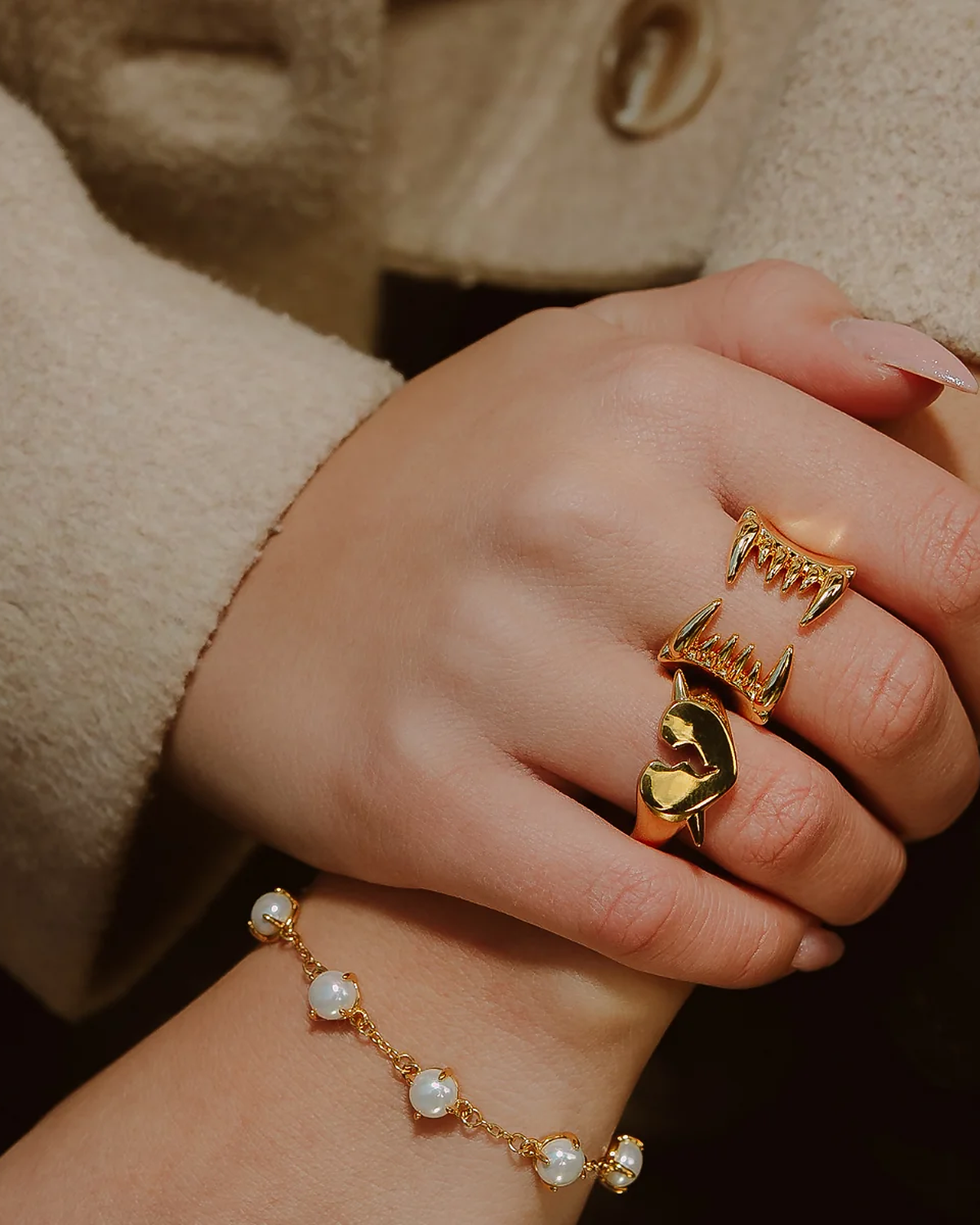 Modell med Pearl Fang Bracelet i gull på håndleddet